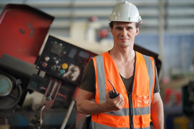 Ingénieur métallurgiste opérateur industriel expérimenté technicien ouvrier dans un casque de sécurité travaillant sur une machine de tour, homme professionnel dans l'atelier d'usine de fabrication de technologie industrielle