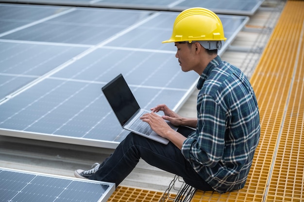 Ingénieur ouvrier technologie cellule solaire Ingénieur asiatique travaillant sur le toit d'une usine vérifiant le système d'alimentation des cellules solaires pour le projet réduire l'utilisation de l'électricité dans l'usine