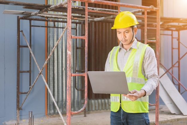 Un ingénieur regarde le plan d'étage sur le chantier de construction.