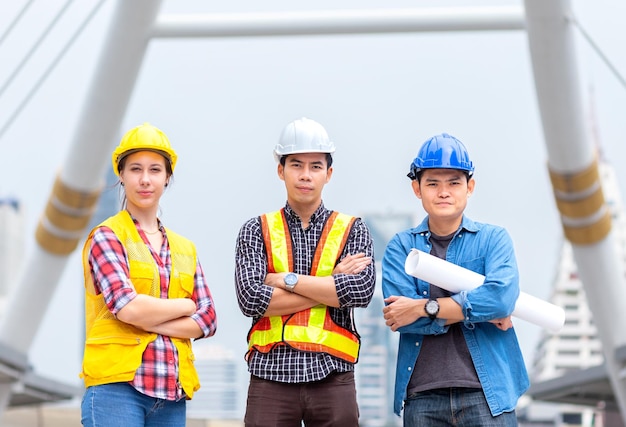 L'ingénieur de la réussite discute et travaille avec le plan et porte le chantier de construction d'un casque de sécurité