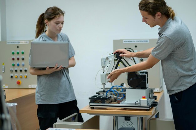 Ingénieur en robotique en stage apprenant avec la main robotique de programmation et de manipulation