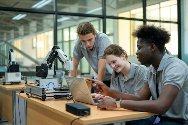 Ingénieur en robotique en stage apprenant avec la main robotique de programmation et de manipulation