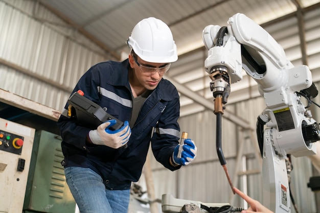 Ingénieur en robotique travaillant sur la maintenance d'un bras robotique moderne dans un entrepôt d'usine