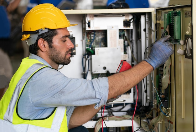 Ingénieur en robotique travaillant sur la maintenance d'un bras robotique moderne dans un entrepôt d'usine