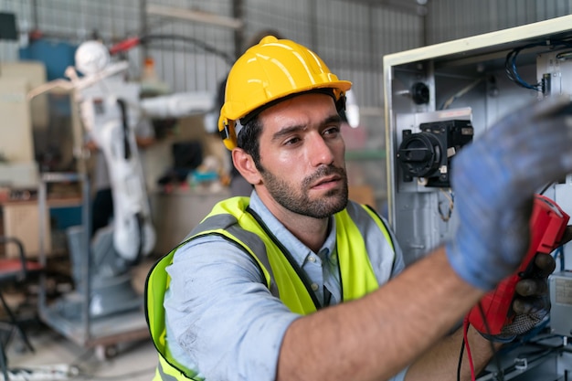 Ingénieur en robotique travaillant sur la maintenance d'un bras robotique moderne dans un entrepôt d'usine