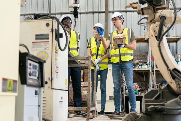 Ingénieur en robotique travaillant sur la maintenance d'un bras robotique moderne dans un entrepôt d'usine