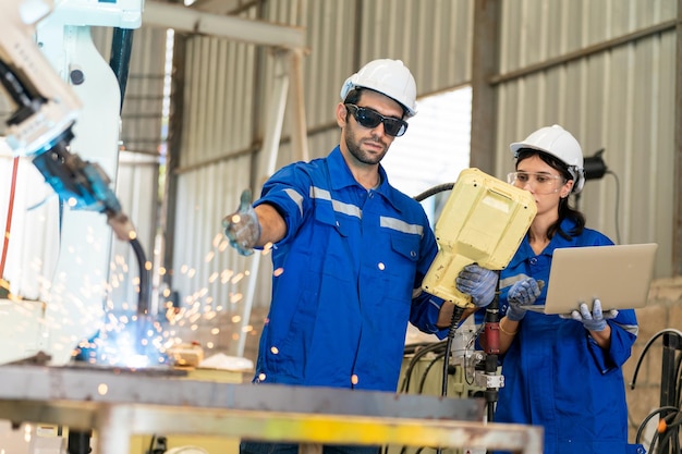 Ingénieur en robotique travaillant sur la maintenance d'un bras robotique moderne dans un entrepôt d'usine