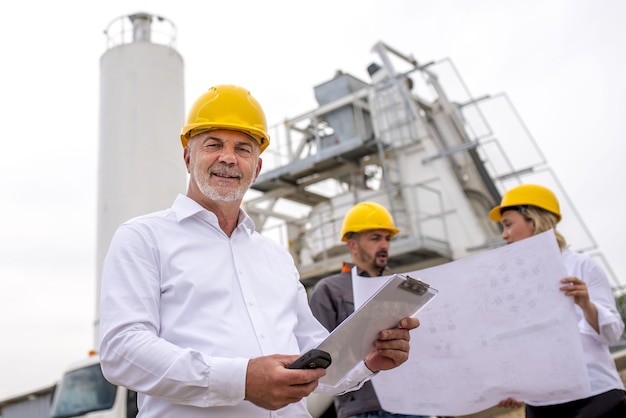 Ingénieur senior souriant avec ses collègues sur un chantier de construction