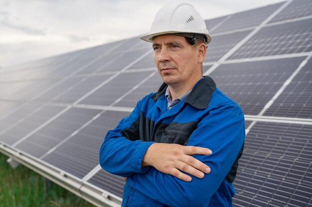 Photo ingénieur de service homme debout avec les bras croisés devant la maintenance des techniciens de panneaux solaires