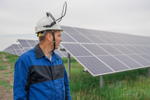 Photo ingénieur de service homme debout devant un technicien de panneaux solaires maintenance des cellules solaires sur l'énergie solaire