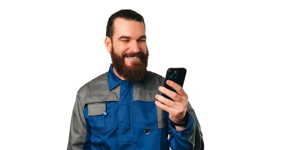 Un ingénieur souriant portant un uniforme bleu répond aux appels téléphoniques à venir