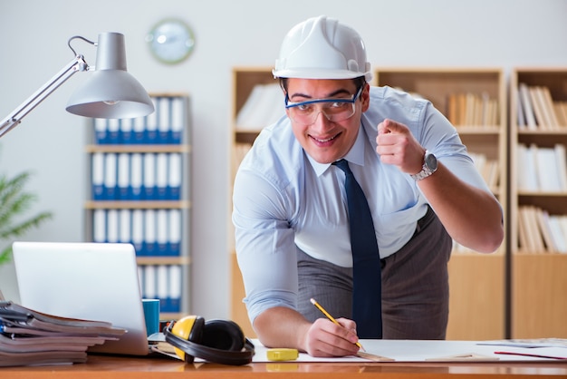 Ingénieur superviseur travaillant sur des dessins au bureau