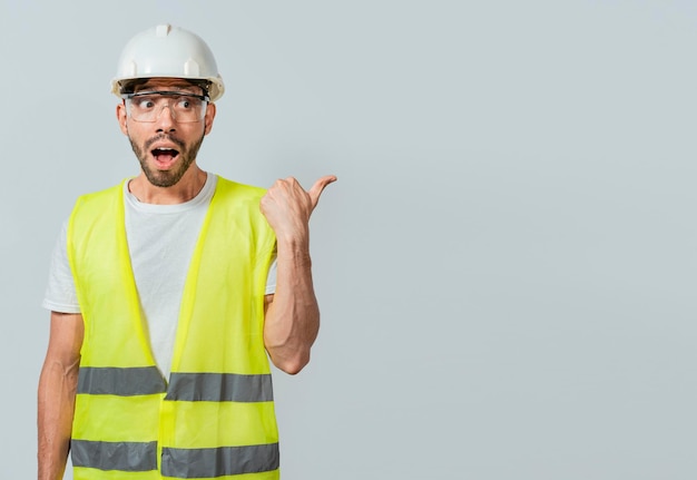 Ingénieur surpris pointant vers le côté Ouvrier du bâtiment au visage surpris pointant une publicité Homme ingénieur pointant vers le côté Ingénieur au visage surpris pointant le doigt vers la droite