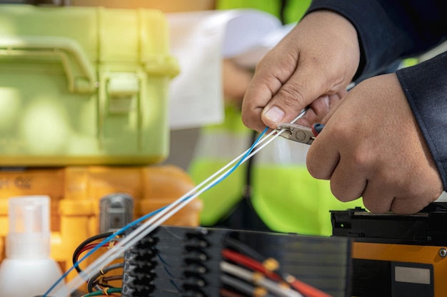 Un ingénieur ou un technicien coupe des lignes de câbles à fibres optiques pour la maintenance