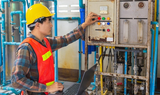 Ingénieur travaillant à l'aide d'un ordinateur tablette pour vérifier le système de gestion de l'eau dans l'usine d'eau