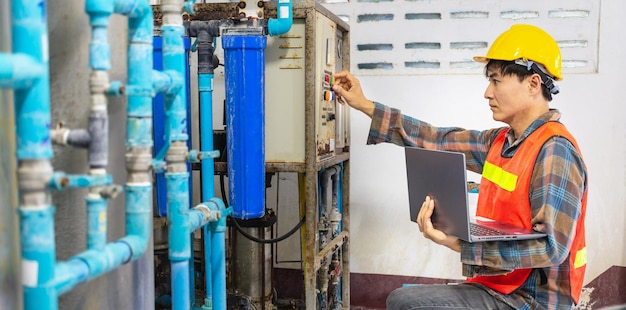 Ingénieur travaillant dans une usine d'eau potable utilisant une tablette pour vérifier le système de gestion de l'eau