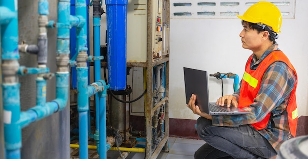 Ingénieur travaillant dans une usine d'eau potable utilisant une tablette pour vérifier le système de gestion de l'eau