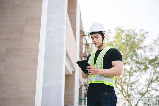 Ingénieur ou travailleur de la construction avec casque de protection travaillant sur le chantier