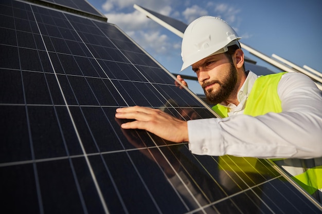 Ingénieur en uniforme examinant le panneau d'énergie solaire