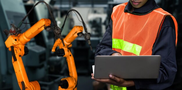 L'ingénieur utilise un logiciel robotique avancé pour contrôler le bras du robot industriel en usine