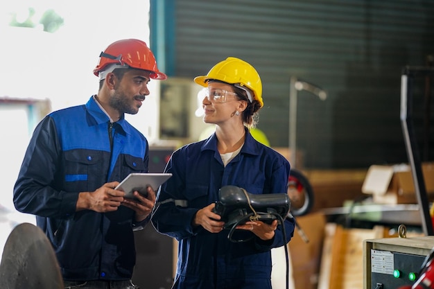 Ingénieur vérifiant le panneau de commande et enseignant le nouveau bras de robot automatique et la machine de contrôle d'exploitation en usine