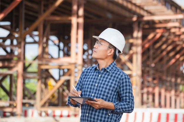 Photo ingénieur vérifiant le projet sur le chantier d'infrastructure