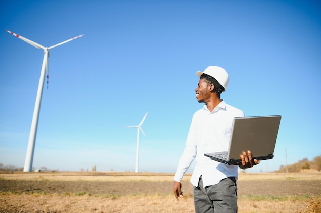 L'ingénieur vérifie le système d'éolienne avec une tablette. Énergie alternative. Parc éolien. Technologies d'énergies renouvelables propres. Les centrales éoliennes