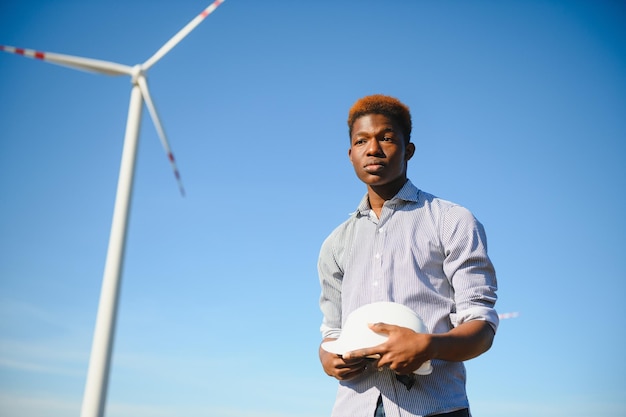 L'ingénieur vérifie le système d'éolienne avec une tablette. Énergie alternative. Parc éolien. Technologies d'énergies renouvelables propres. Les centrales éoliennes