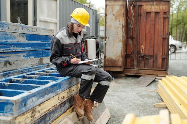 Ingénieure moderne en vêtements de travail dessinant un croquis de construction