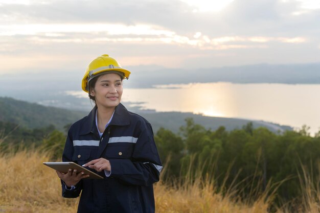 Une ingénieure porte un casque de protection sur la tête à l'aide d'une tablette Analytics