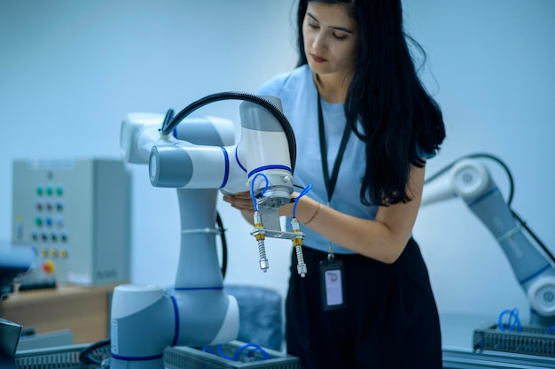 Ingénieure en robotique travaillant avec la main robotique de programmation et de manipulation