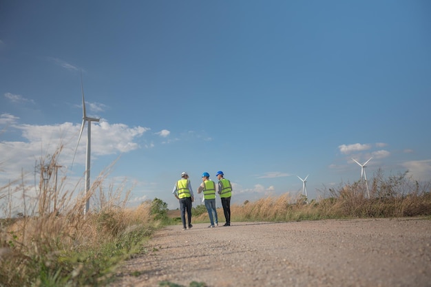 Ingénieurs asiatiques travaillant sur le terrain en plein air Travailleurs marchant et inspectant la construction et la machine autour du site du projet Éolienne électrique de ressources propres énergétiques et environnementales durables