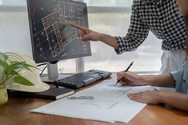 Photo les ingénieurs discutent d'un plan tout en vérifiant les informations sur une tablette dans un bureau