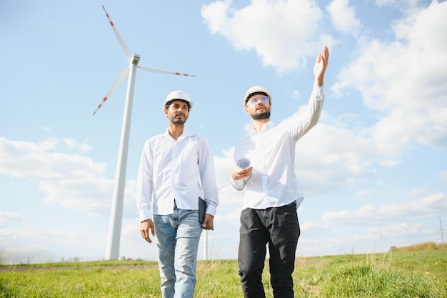 ingénieurs indiens et européens travaillant sur un parc éolien avec des moulins à vent