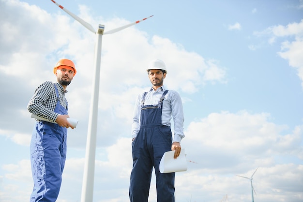 ingénieurs indiens et européens travaillant sur un parc éolien avec des moulins à vent