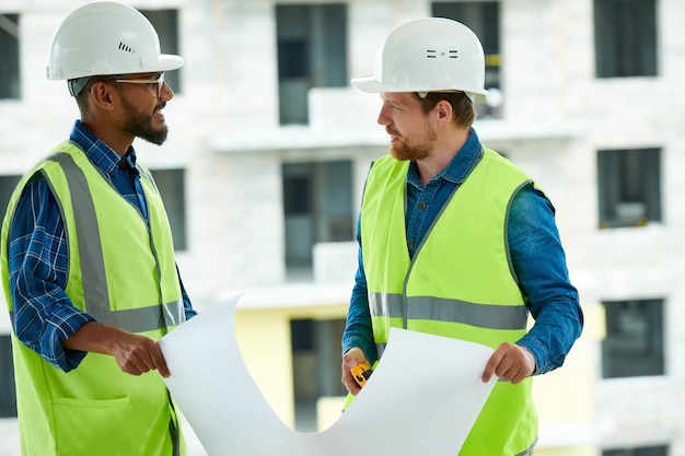 Des ingénieurs multiethniques discutent d'un projet de construction