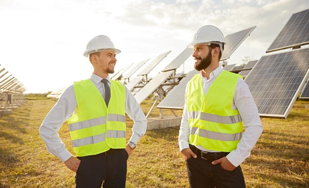 Ingénieurs souriants sur le terrain avec des panneaux photovoltaïques
