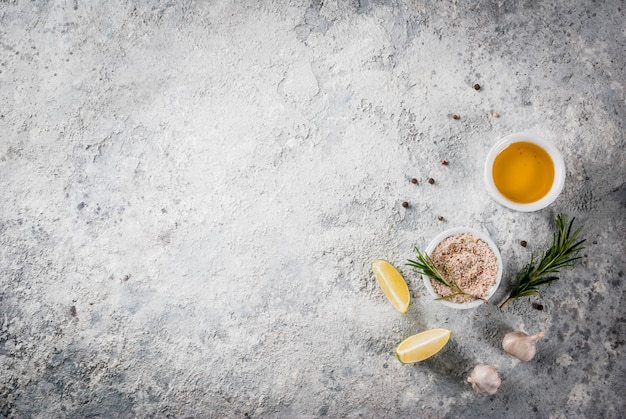 Ingrédient de cuisson des aliments, huile d'olive, herbes et épices, copyspace en pierre grise vue de dessus