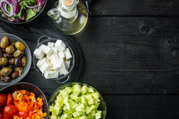 Ingrédient de la salade grecque de cuisson, sur fond de table en bois noir avec espace de copie pour le texte