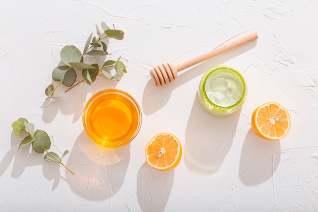 Ingrédients biologiques naturels pour la fabrication de crème cosmétique : avocat, miel, citron et eucalyptus sur fond de pierre blanche, cosmétiques et soins de la peau biologiques pour les produits de soins du visage et du corps, lumière du soleil dure