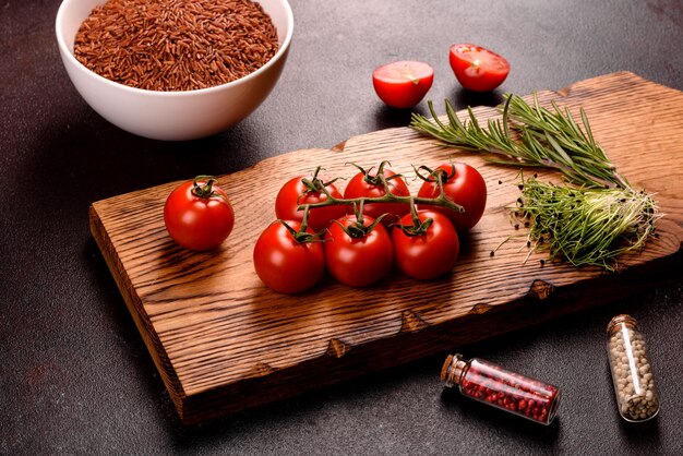 Les ingrédients de la cuisine indienne sont sur une surface noire. La composition du plat comprend du riz brun, des herbes et des épices.