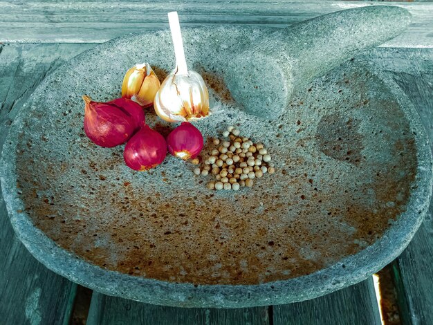 Photo ingrédients de cuisine simples oignon ail poivre dans cobek outil de lissage de pierre en indonésie