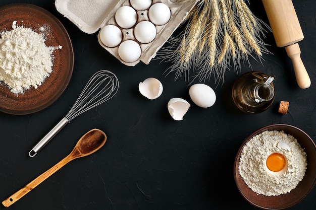 Ingrédients de cuisson des pâtes sur une table de cuisine noire Vue de dessus avec un espace pour votre texte