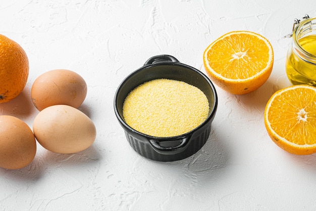 Ingrédients du gâteau de polenta à l'orange avec des œufs et du miel sur fond de table en pierre blanche