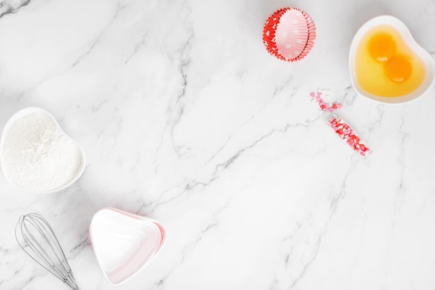 Ingrédients et formes pour la cuisson des gâteaux sur table en marbre. Concept cuisiner avec amour, cuisiner pour vos proches, cuisiner pour la Saint-Valentin. Vue de dessus. Copier l'espace