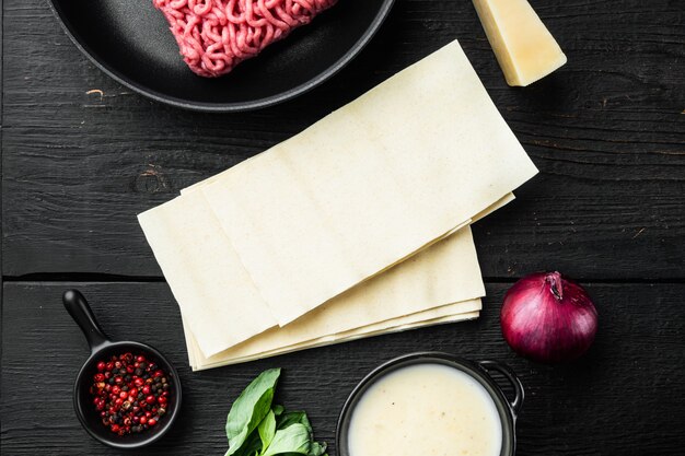 Ingrédients frais pour la lasagne, sur fond de table en bois noir