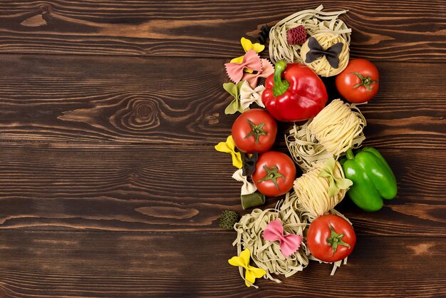 Ingrédients de pâtes italiennes sur fond de pâtes Vue de dessus de table en bois Variété de pâtes et de légumes