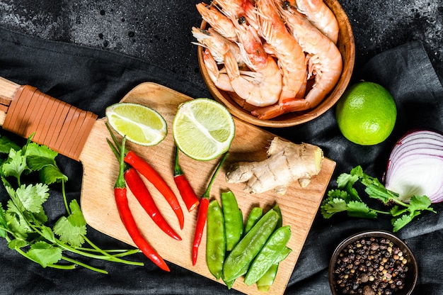 Ingrédients pour cuisiner Tom Kha Gai. Soupe de poulet thaï au lait de coco. Surface noire. Vue de dessus