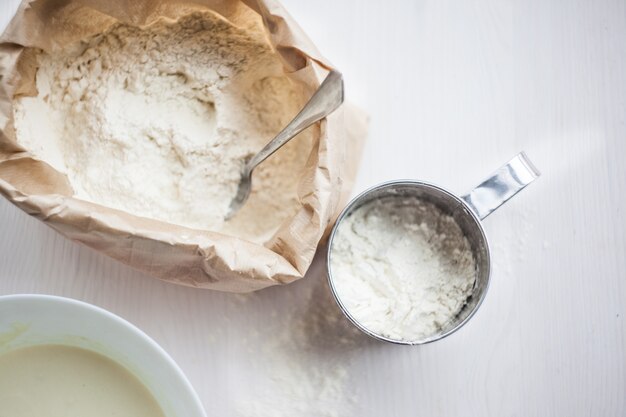 Ingrédients pour la cuisson du gâteau posé sur une table en bois blanche. mise au point sélective