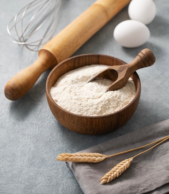 Ingrédients pour la cuisson des œufs de farine, rouleau à pâtisserie et textiles de cuisine sur fond bleu